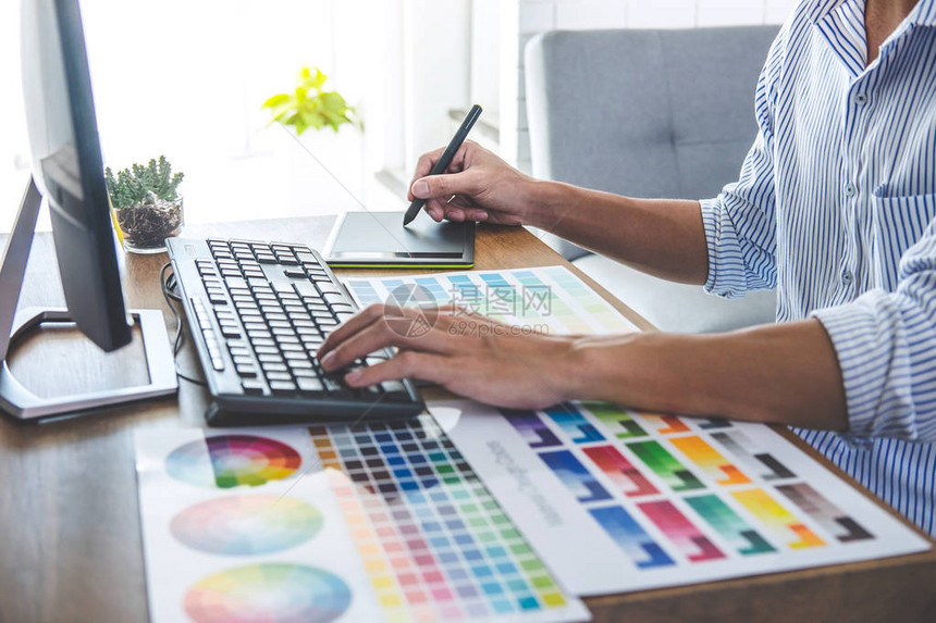 男创意平面设计师在工作场所使用工作具和配件在工作场所进行颜色选择和绘图片