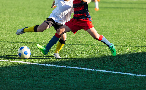 穿着红色白运动服的男孩在足球场上奔跑年轻的足球运动员在比赛中运球和踢足球训练积极生活方式运动背景图片