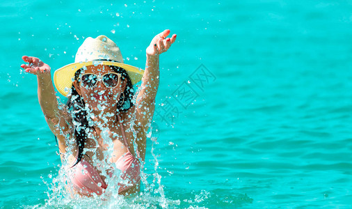身穿粉色泳衣的快乐亚洲年轻女在热带天堂海滩放松身心图片
