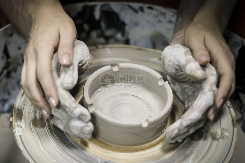 女人的手牵着男人的手男人的手在粘土中在陶艺大师班上图片