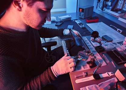 技师在现代修理车间修理一台破损的平板电脑图片