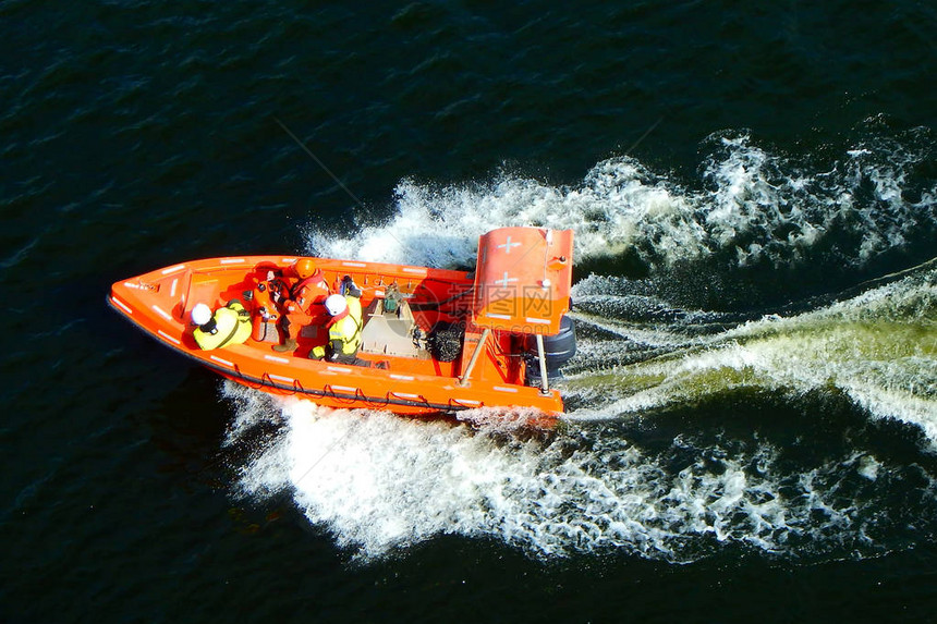 身穿救生衣的人在橙色救援安全船图片