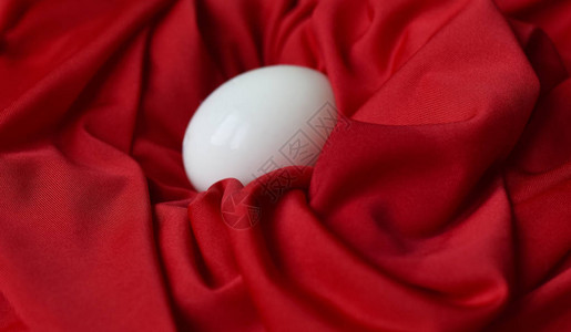 红色织物上的鸡煮蛋清背景图片