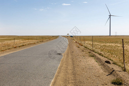 草原沥青路地平线上有风力发电机图片