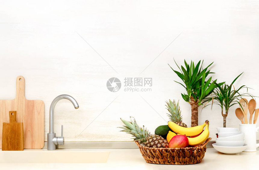 现代家居厨房桌顶上装饰的夏季异国水果篮子和热带植物图片