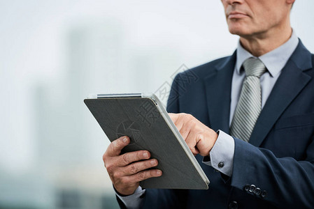 平板电脑上中年商人阅读文背景图片