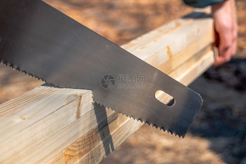 在木工或木工作期间用手锯或钢锯或切图片