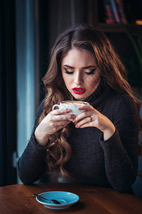 美丽的年轻女子享受咖啡卡布奇诺咖啡和咖啡馆窗图片
