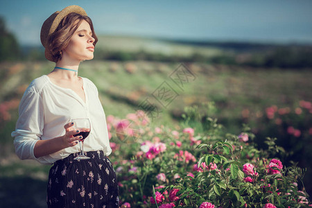 一个乡村女孩在香玫瑰花园享受日落葡萄图片