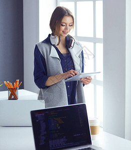 耳机中专注的女坐在台前用笔记本电脑看屏幕做笔记在互联背景图片