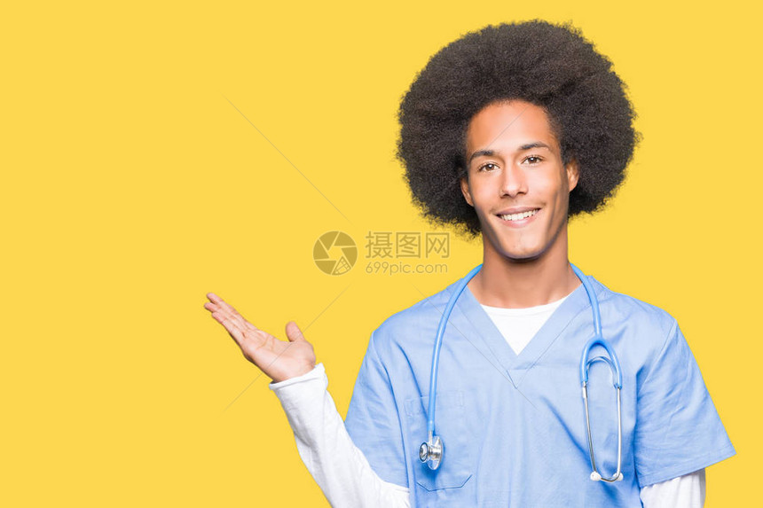 年轻的非洲美籍医生长着头发笑地展示和用手掌指着镜头看图片