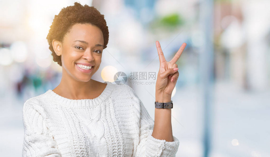 美丽的年轻非洲裔美国女人穿着毛衣在孤立的背景下微笑图片