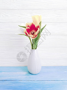 木制背景上的郁金香花瓶图片