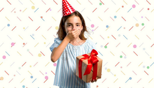 在生日派对上的小姑娘拿着礼物用满的彩色背景图片
