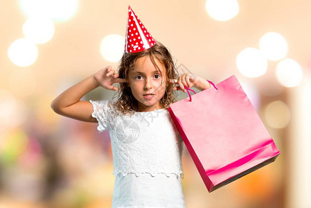 一个生日派对上的小姑娘拿着一个礼物袋用无重点背景的手把图片