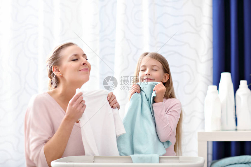 美丽的年轻女子和少女在家洗衣服时玩得图片