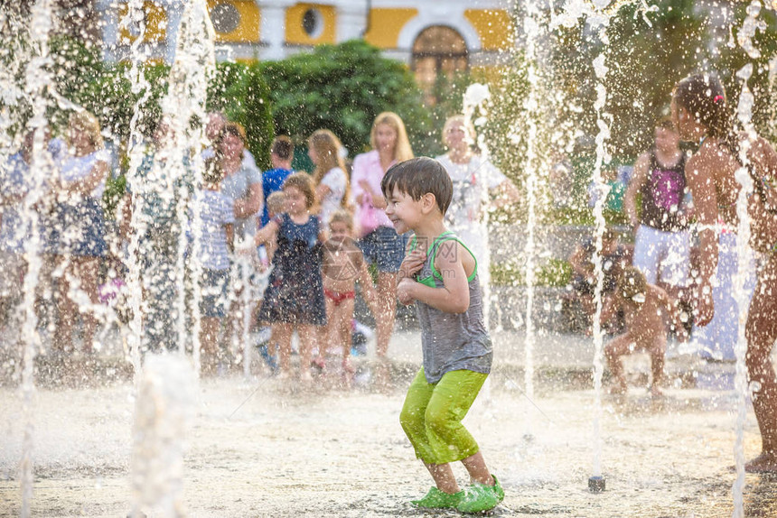 兴奋的男孩在喷泉里玩得开心图片