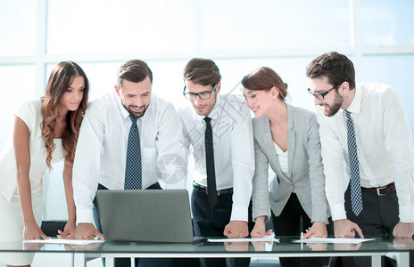 商业团队站在台式桌面附近照片图片