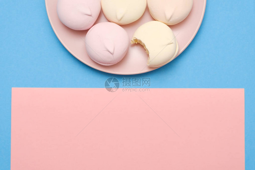 蓝色和粉红色背景板上的美味和甜美的圆形棉花糖图片