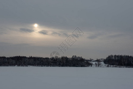 雪下深冬的冰冻水体河流或湖泊岸上的树木图片