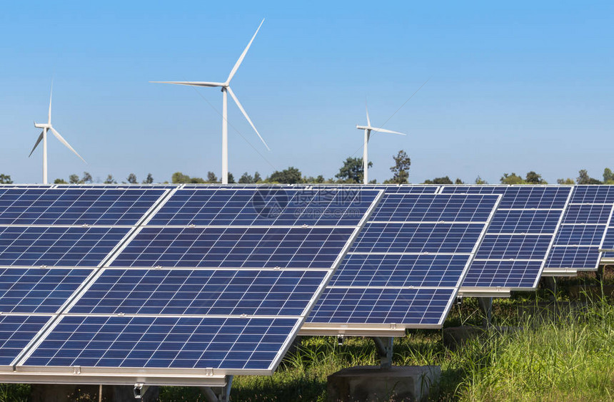 在混合发电厂系统中发电的多晶硅太阳能电池板和风力涡轮机的行阵列从自然中提取可替图片