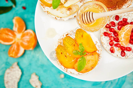 配热带水果石榴橘子柿子苹果简单的早餐蓝色背景夏季素食主义者图片