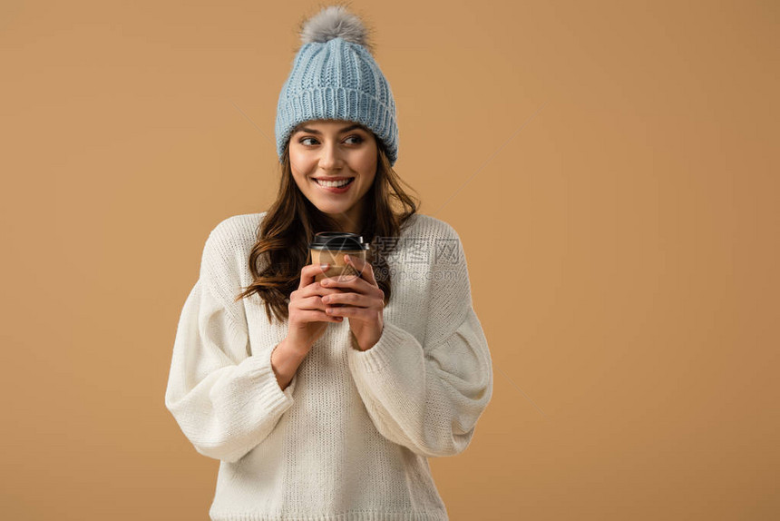 穿着编织帽子的快乐女孩拿着咖啡笑着在图片