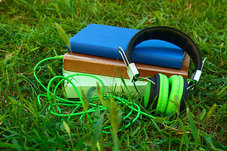 现代耳机和绿色草地书籍图片