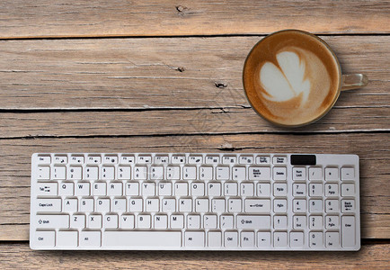 黑咖啡和泡沫电脑键盘放在桌面上图片