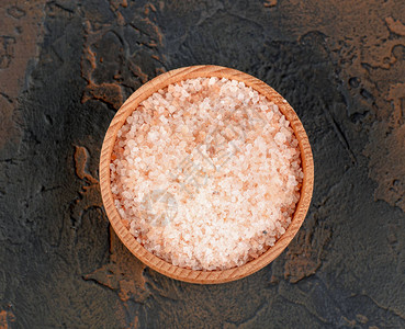 黑色背景木碗中的粉红色喜马拉雅盐图片