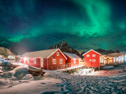 夜间冬天季在北极上带北极光的捕鱼村红房子图片