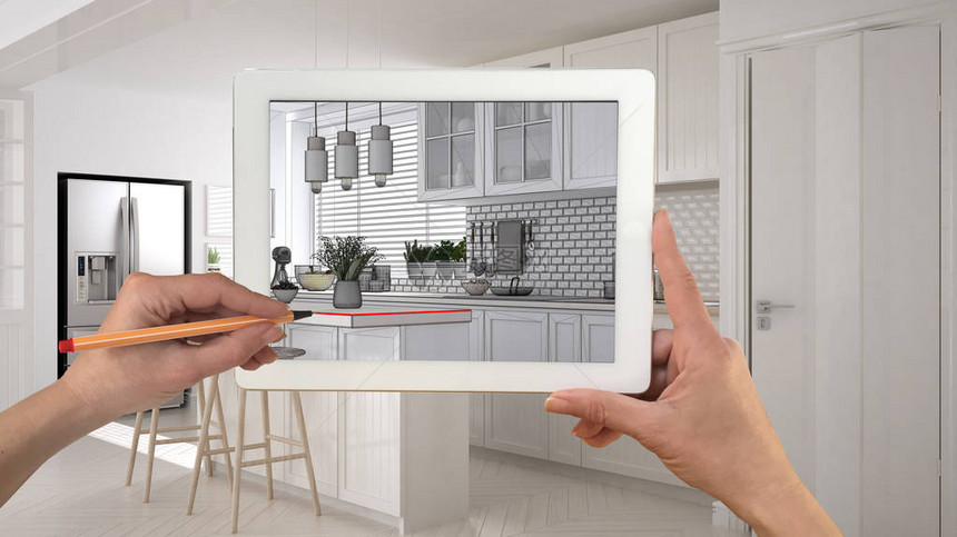 手持和绘图的平板电脑显示斯堪的纳维亚白色厨房与木制细节CAD草图背景中真正完成的室内设计图片