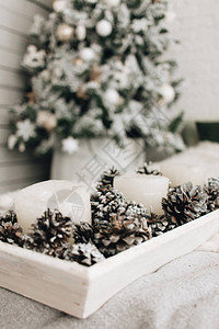 用白色蜡烛和松果装饰圣诞图片