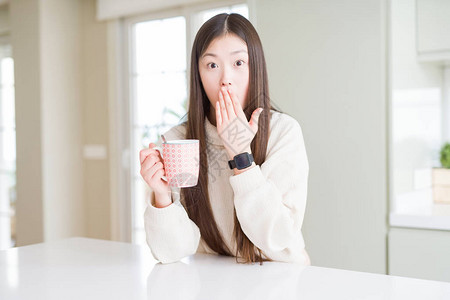 美丽的亚洲女人喝着一杯咖啡图片