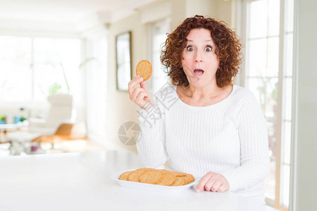 在家吃健康全麦饼干的老妇人吓得一脸吃惊图片