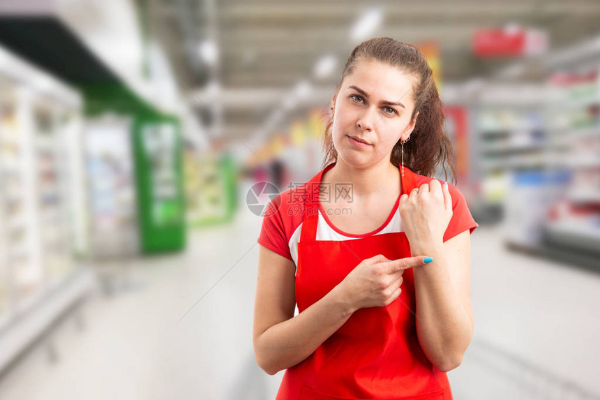 女店主或员工用食指着手腕为工作概念迟到了图片