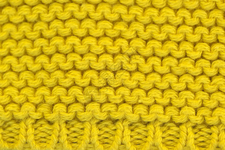 编织机器编织毛线的黄色背景近图片