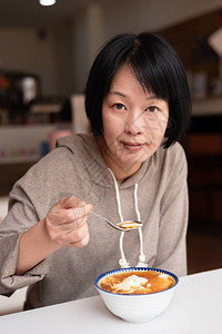 亚洲女人在商店吃豆腐布丁高清图片