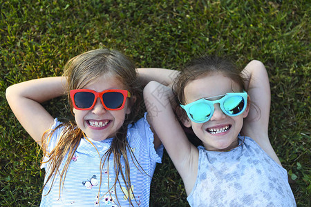 欢笑着孩子们戴着太阳眼镜在夏日图片
