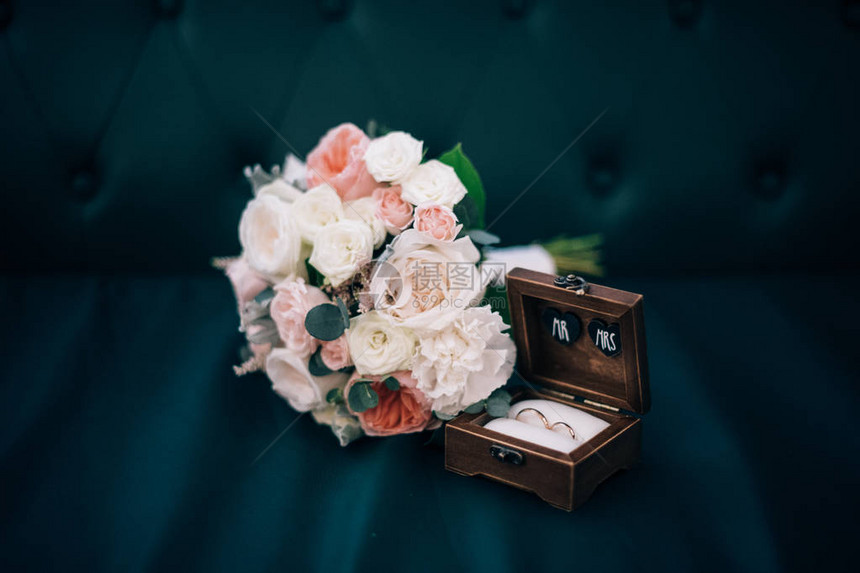 木盒中的结婚戒指和新娘花束图片