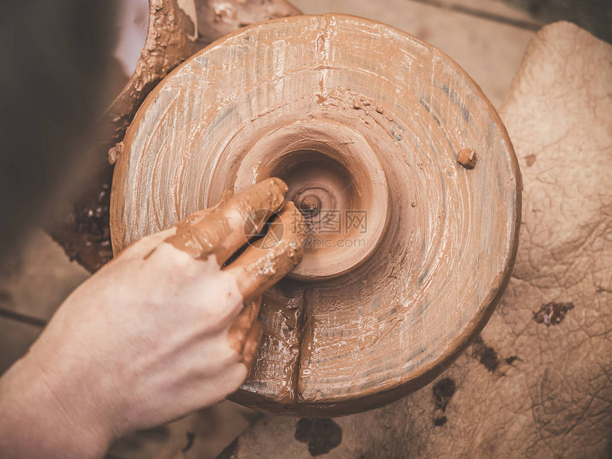 旋转的陶轮和陶器从上面拍摄A在陶轮上用陶杯雕刻双手中的粘土陶艺男陶艺家创造了一种手工制作的粘土图片