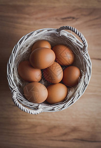 木桌上柳条篮中的新鲜鸡蛋准备鸡蛋和鸡蛋搅拌器图片