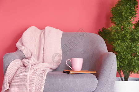 一杯热茶和扶手椅上的格子布图片