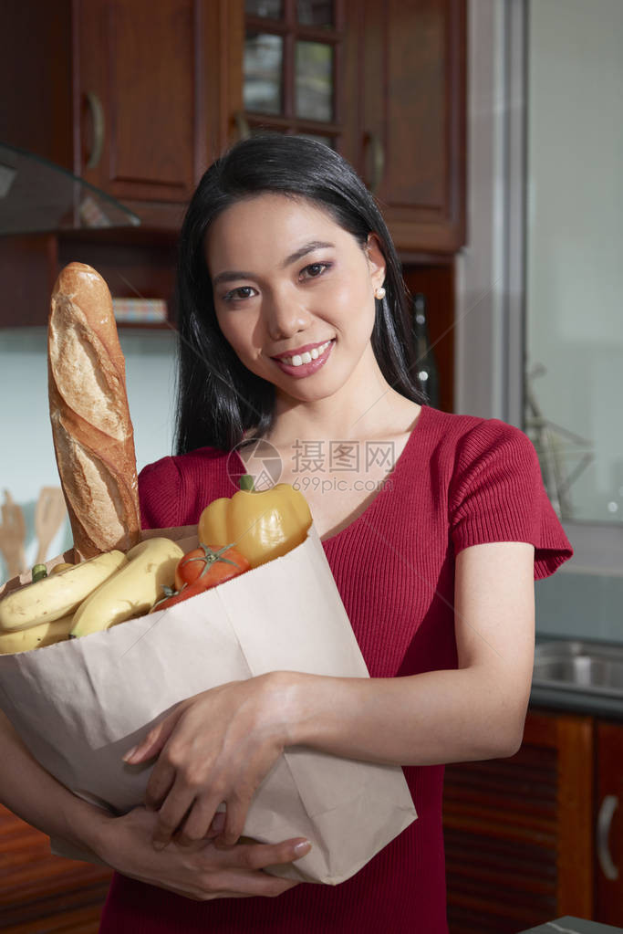 微笑着的越南年轻女子拿着纸袋图片