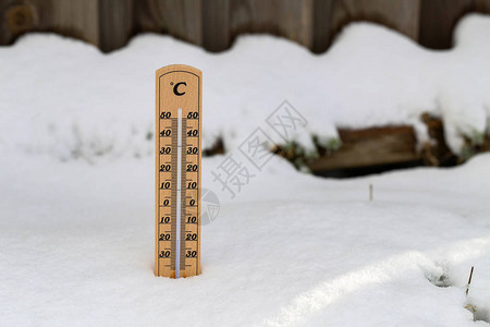 在雪中站立木质温度计图片