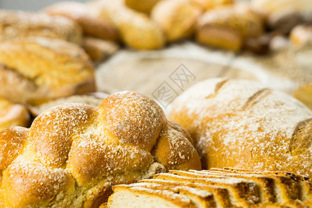 木桌面粉上各种美味的面包图片