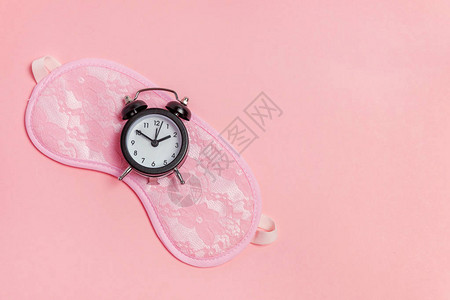 闹钟隔离在粉红色柔和的彩色时尚背景上图片