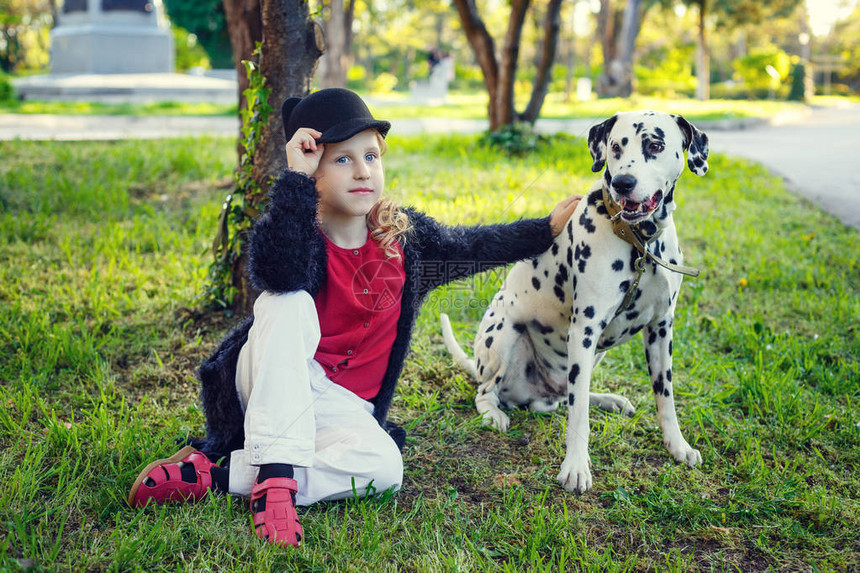 年轻女孩带着她的达马特犬在春天公园里图片