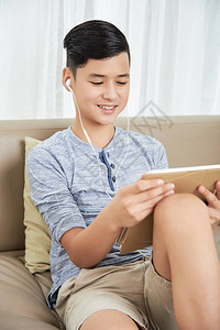 微笑的少年男孩在观看平板电脑录背景图片