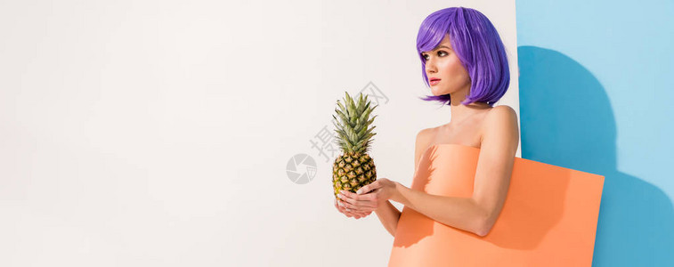 披着菠萝的珊瑚纸板上涂满紫色头发的漂亮女孩图片